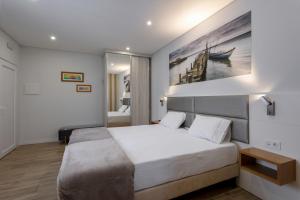 1 dormitorio con 1 cama con una pintura en la pared en Casanossa, en Setúbal