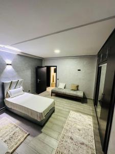 a bedroom with two beds and two rugs at Petite villa a hay dakhla in Agadir