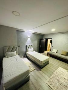 Habitación de hotel con 2 camas y 2 alfombras en Petite villa a hay dakhla, en Agadir
