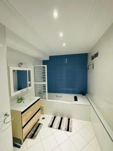 a bathroom with a tub and a sink and a mirror at Petite villa a hay dakhla in Agadir