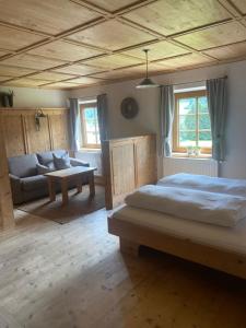 1 dormitorio grande con 1 cama y 1 sofá en Ferienwohnungen Peisserhof en Sillian