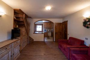 a living room with a red couch and a tv at Residence L'Arcobi in Livigno