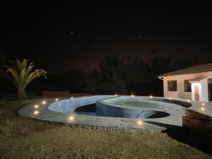 a swimming pool at night with lights around it at Hotel Poneloya in Tarija