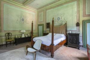 1 dormitorio con 1 cama y 1 silla en Villa Sardi Small Luxury boutique Hotel en Lucca
