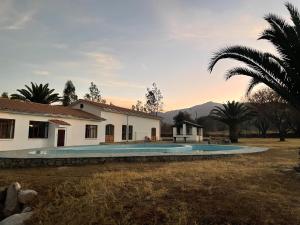 a villa with a swimming pool in front of a house at Hotel Poneloya in Tarija