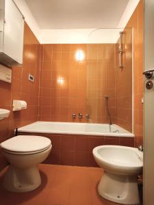a bathroom with a toilet and a bath tub at Hostdomus - Sansicario R9 in Cesana Torinese