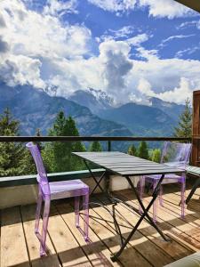 a table and chairs on a balcony with a view of mountains at Hostdomus - Sansicario R9 in Cesana Torinese