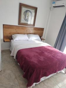 een slaapkamer met een bed met een rode en witte deken bij La Bonita in Ezeiza