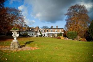 a large house with a statue in the middle of a yard at Ringwood Hall Hotel & Spa in Chesterfield