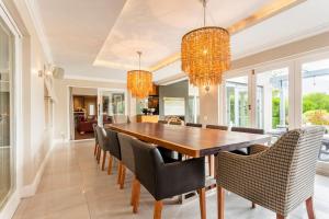 uma sala de jantar com uma mesa de madeira e cadeiras em Luxe Family Home with Solar Power in Secure Hout Bay Estate na Cidade do Cabo