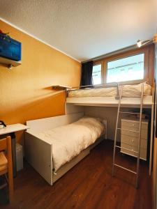 a bedroom with two bunk beds and a desk at Hostdomus - Sansicario R9 in Cesana Torinese