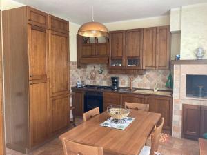 a kitchen with wooden cabinets and a wooden table at appartamento in Nocera Umbra