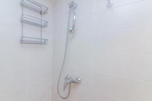 a shower with a hose in a bathroom at Bright duplex apartment for families-VICALV in Madrid