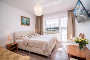 - une chambre avec un lit, un bureau et une fenêtre dans l'établissement Dom Wczasowy Klif & Spa, à Władysławowo