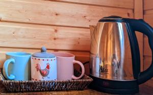 a basket with two coffee mugs and a kettle at SWEEPH in Mestia