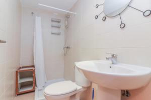 a white bathroom with a sink and a toilet at Bright duplex apartment for families-VICALV in Madrid