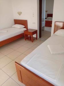 a room with two beds and a table in it at Georgina in Agia Marina Nea Kydonias