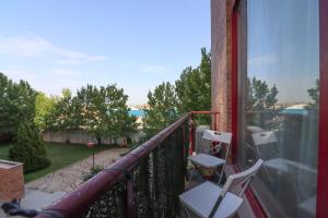 - un balcon avec deux chaises et une vue sur l'eau dans l'établissement Bright duplex apartment for families-VICALV, à Madrid