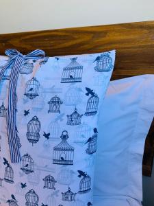 Una almohada azul con aves en jaulas. en Maritimus Suites 06, en Barretos