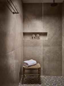 a shower stall with a bench in a bathroom at Uvetta Villa in Makhairádhon
