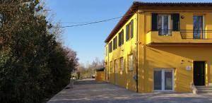 a yellow building with a balcony on the side of it at casadelfalegname ABETE 