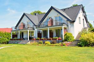 a large white house with a yard at Willa u Piotra in Sitno