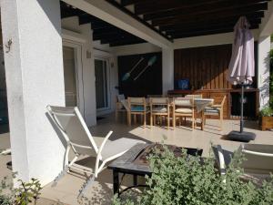 a patio with chairs and a table and an umbrella at Casa 9 personas Punta Puyai Papudo in Papudo