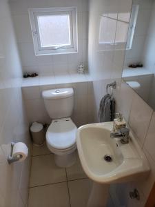 a white bathroom with a toilet and a sink at Casa 9 personas Punta Puyai Papudo in Papudo