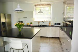a kitchen with white cabinets and a black counter top at Willa u Piotra in Sitno