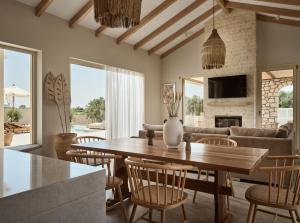 a living room with a wooden table and chairs at Uvetta Villa in Makhairádhon