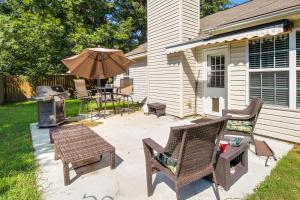 a patio with a table and chairs and an umbrella at Pet-Friendly Savannah Rental with Community Pool! in Savannah