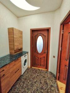 a laundry room with a door and a washing machine at Dream house in Gabala