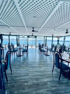 een eetkamer met tafels en stoelen en de oceaan bij The Cove Motel & Restaurant in Aulds Cove