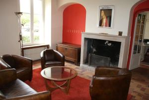 ein Wohnzimmer mit Ledersesseln und einem Kamin in der Unterkunft Le Prieuré: maison de charme proche de Vézelay**** 