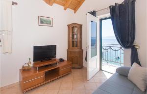 a living room with a tv and a sliding glass door at Gorgeous Home In Brist With House Sea View in Brist
