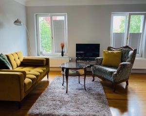 a living room with a couch and two chairs and a table at Vintner Suites in Neustadt an der Weinstraße