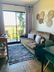 un soggiorno con divano e balcone di Maritimus Suites Apartamento 07 a Barretos