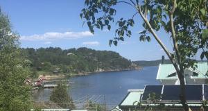 a view of a river with a house and trees at Nannas Studio in Henån