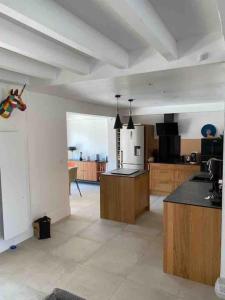 een grote kamer met een keuken met houten kasten bij Nouveau Villa vue mer, proche centre et plage in Fréjus