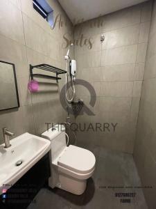 Łazienka z białą toaletą i umywalką w obiekcie Villa The Quarry w mieście Segamat