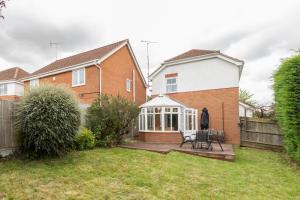 a person standing in the yard of a house at Chelmsford Reach 3 bed house near centre,free parking, Wi-Fi, table football in Chelmsford