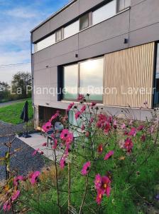 ein Gebäude mit rosa Blumen davor in der Unterkunft La planque du raton laveur in Lierneux