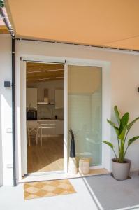 uma porta de vidro deslizante aberta com uma cozinha ao fundo em VILLA AMBROSIA 172 A em Terracina