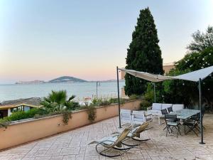 eine Terrasse mit Stühlen, einem Tisch und einem Sonnenschirm in der Unterkunft Residenza Gli Oleandri in Formia