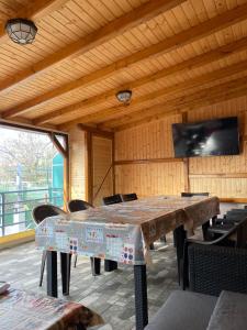 a large table in a room with chairs and a television at Casa Alex in Constanţa