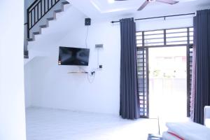 ein Wohnzimmer mit einem an der Wand hängenden TV in der Unterkunft Green Dream Homestay 2 Kota Bharu Town 3 Aircond Room With Wifi & Netflix in Kota Bharu