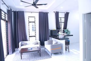 ein Wohnzimmer mit einem Deckenventilator und einem Spiegel in der Unterkunft Green Dream Homestay 2 Kota Bharu Town 3 Aircond Room With Wifi & Netflix in Kota Bharu