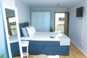a small bedroom with a bed and a mirror at Луксозен Апартамент в Модерна сграда -Молимаркс Делукс Апартамент Бургас in Burgas City +40 photos