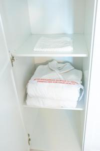 a closet with white shelves and a bed at Луксозен Апартамент в Модерна сграда -Молимаркс Делукс Апартамент Бургас in Burgas City