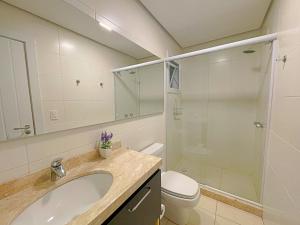 ein Badezimmer mit Waschbecken, Dusche und Toilette in der Unterkunft Espaçoso apto no Centro de Gramado in Gramado + 18 Fotos